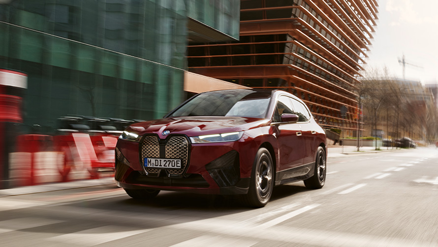 BMW telepaslaugos, važiuojančio BMW iX trijų ketvirčių vaizdas iš priekio BMW telepaslaugos, gatve važiuojančio BMW iX trijų ketvirčių vaizdas iš priekio