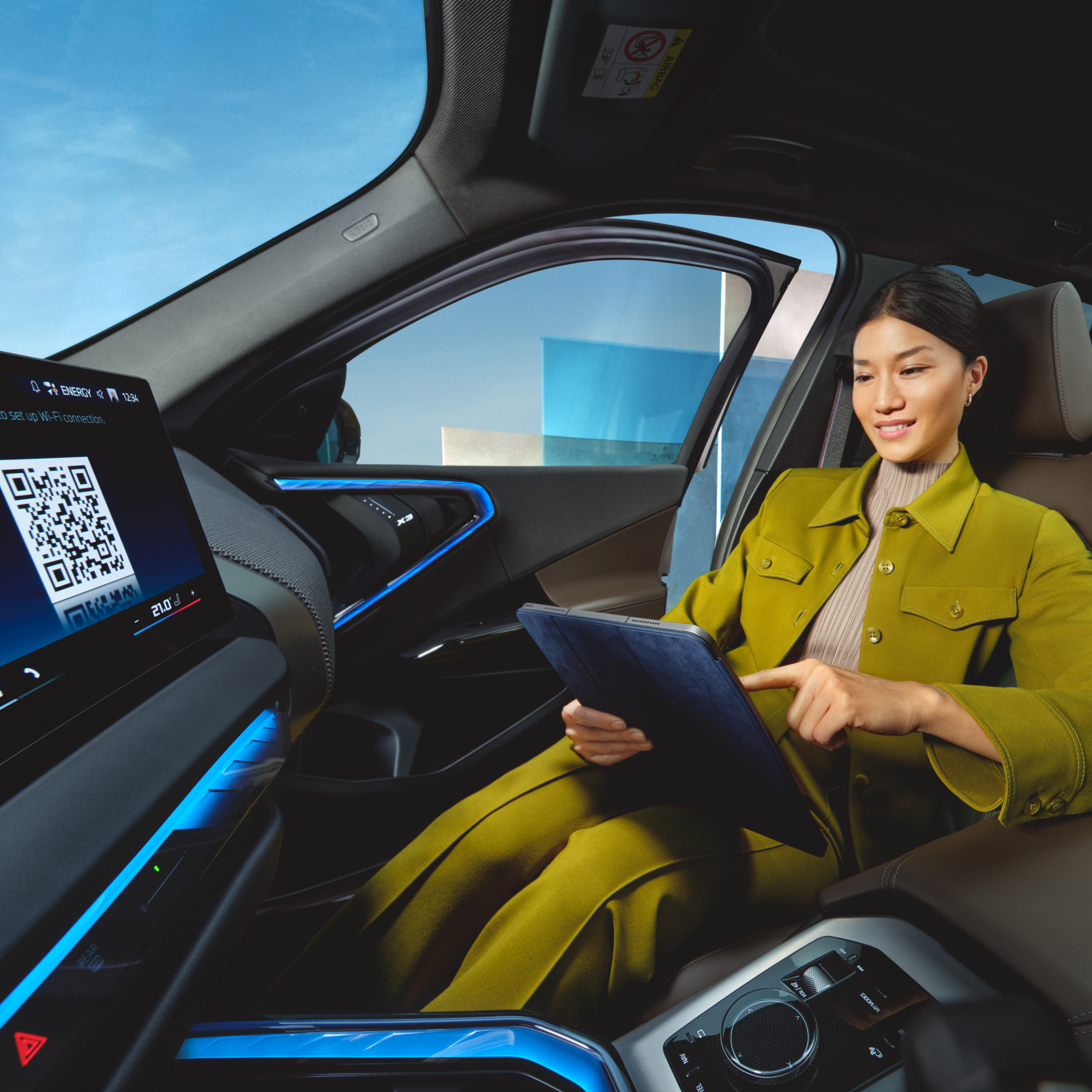 Žmogus BMW automobilyje naudojasi planšetiniu kompiuteriu