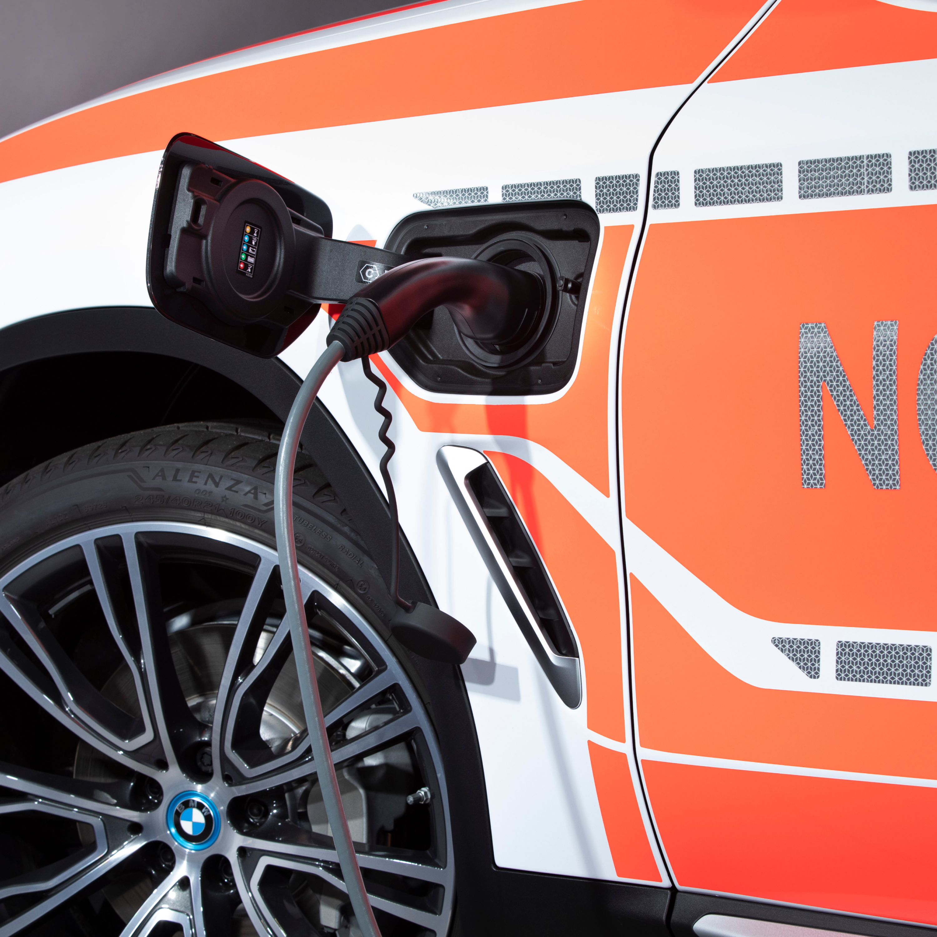 Įkraunamas hibridinis BMW tarnybinis automobilis įkrovimo kabelio vaizdas iš arti